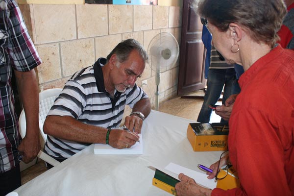 René González dedicando libro