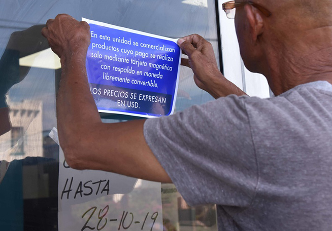 Los trabajadores colocan las señalizaciones pertinentes en las tiendas y acondicionan los locales (Omara García Mederos / ACN)