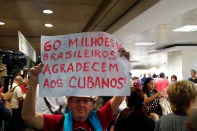 Señor con cartel agradeciendo a los médicos cubanos en Brasil