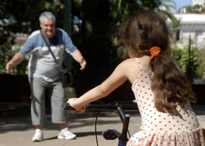 Una niña monta bicicleta con su abuelo