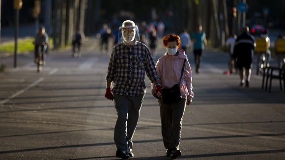 Una pareja usa mascarillas para protegerse del coronavirus en Barcelona, España