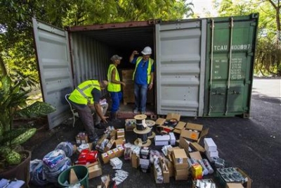 Trabajadores vacían un contenedor cargado de herramientas y materiales de construcción en Finca Vigía Trabajadores vacían un contenedor cargado de herramientas y materiales de construcción en Finca Vigía