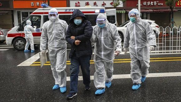 Personal médico traslada a un paciente en Wuhan. Cuatro mil sanitarios chinos viajan al epicentro del brote para reforzar la lucha contra el coronavirus.