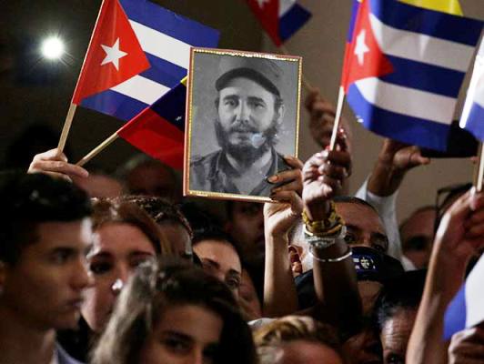 Jóvenes portan banderas y fotos de Fidel