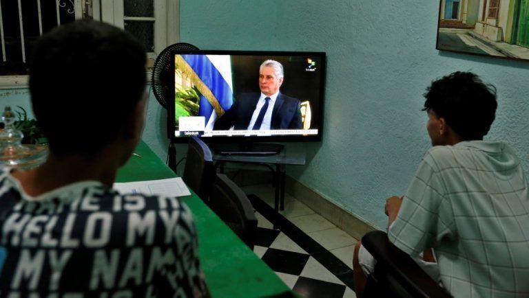 Dos jóvenes ven la entrevista al presidente cubano, Miguel Diaz-Canel, de la cadena de televisión TeleSur, en La Habana. Foto: EFE/Ernesto Mastrascusa