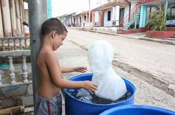 José Daniel de la Torre Sampier sostiene el busto rescatado de José Martí, mientras su hermana se asoma a la puerta de su casa en Punta Alegre, uno de los pueblos que sufrió los peores embates de Irma. Foto: Yander Zamora/ Granma.