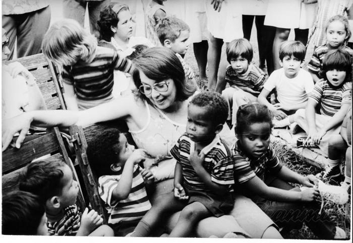  Vilma Espín conversa con los niños que acababan de ser rescatados para calmarlos, luego de haber pasado por terribles y angustiosos momentos dentro del incendiado círculo infantil. Foto: Archivo de Granma 
