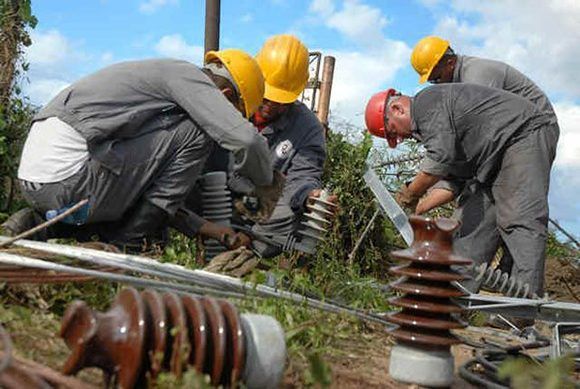 Trabajadores eléctricos restablecen las líneas afectadas. Foto: Juan Pablo Carreras/ ACN/ Archivo.